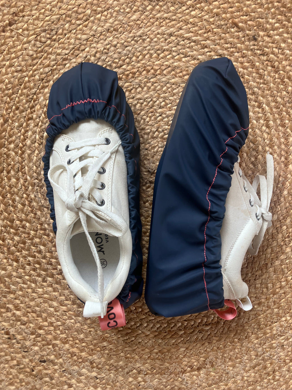 White sneakers with navy shoe covers on a textured surface