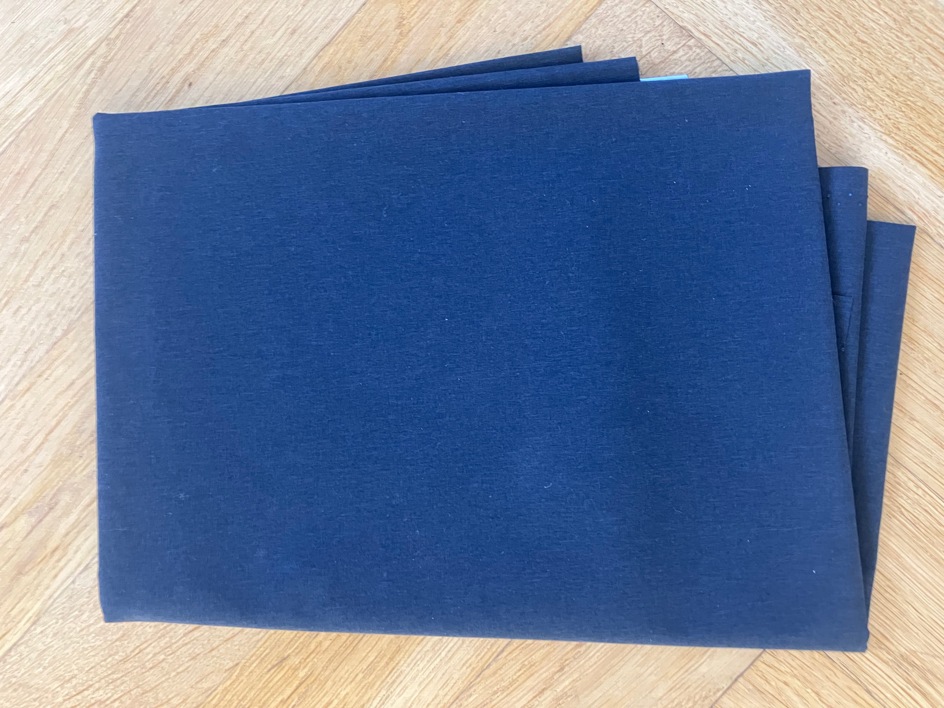 Three blue sheets of paper on a wooden surface