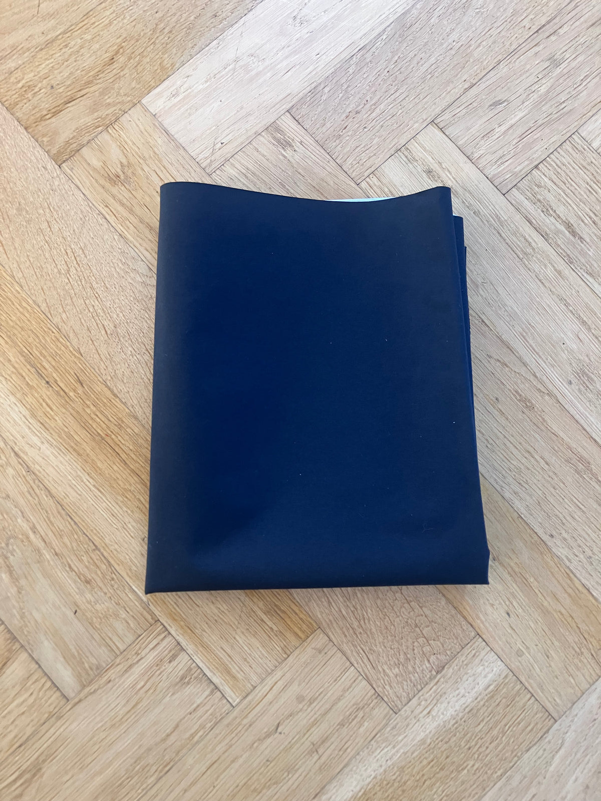Folded navy blue fabric on a wooden floor