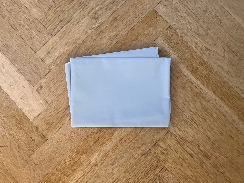 Folded light blue fabric on a wooden floor