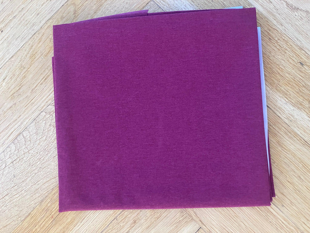 Purple square napkin on a wooden surface