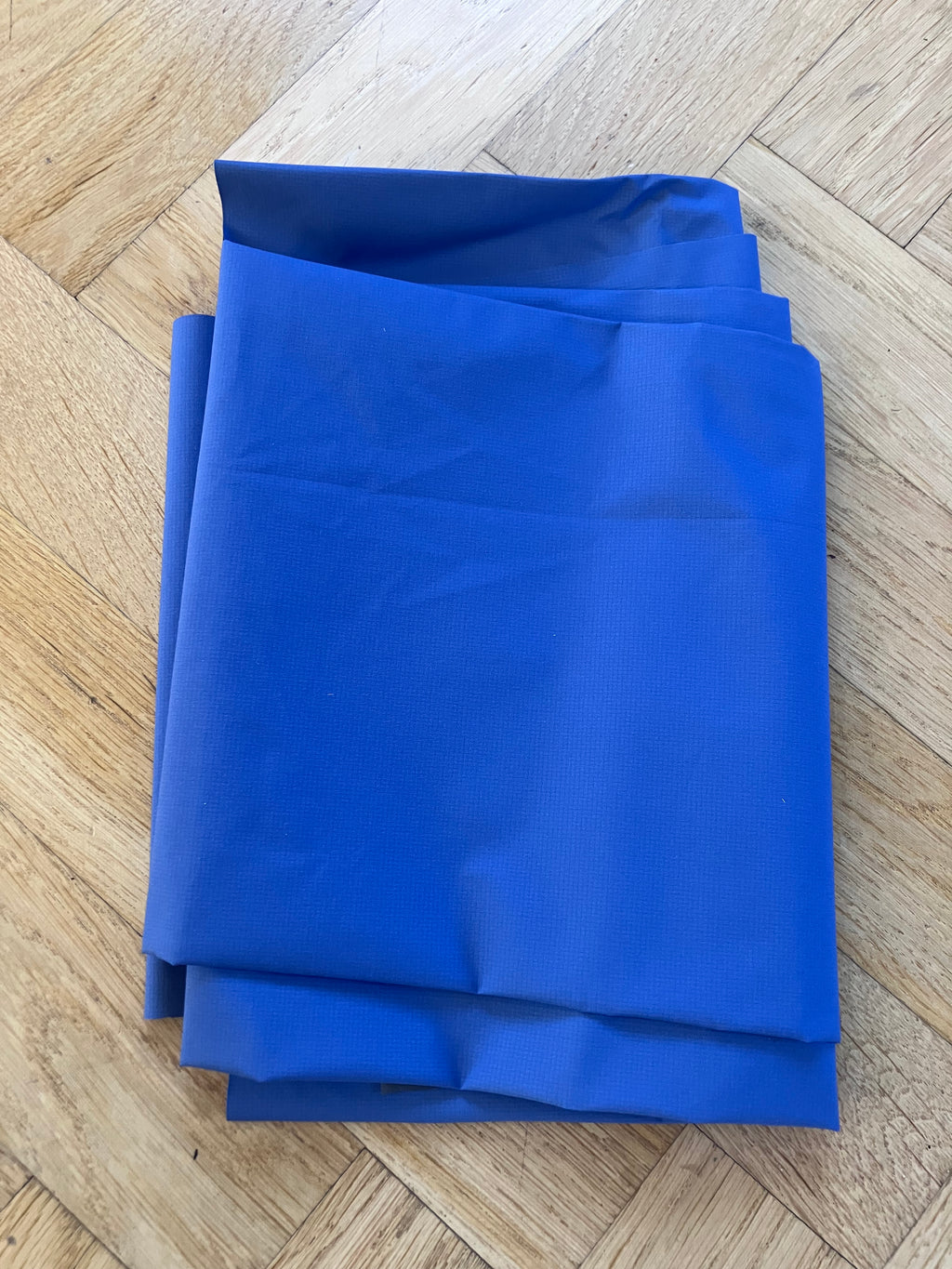 Folded blue sheet on a wooden floor
